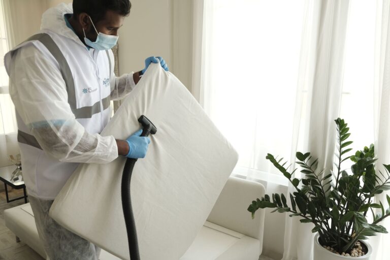 Technician in protective gear treating a mattress